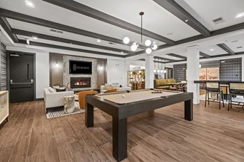 A billiard table is in the middle of a room with a fireplace